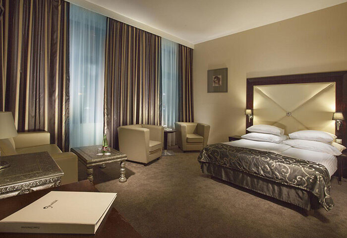 Grandior Hotel Prague room. Cheap luxury gay hotel in Prague Old Town. Room with double bed, chairs, and curtains.