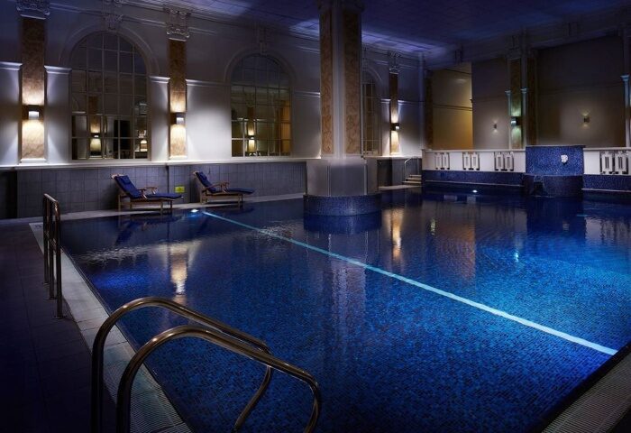 The Dilly Hotel's pool in London. A cheap-luxury gay hotel's pool, with blue tile, lounge chairs, and architectural columns. A Soho, London gem.