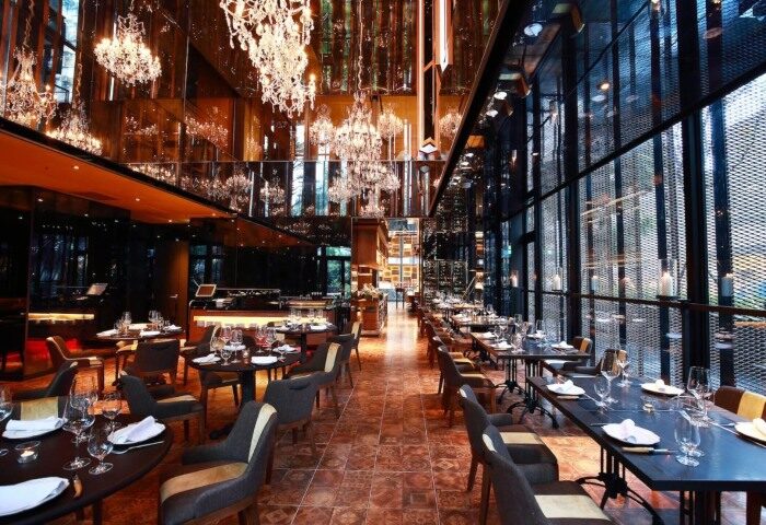 Hotel Proverbs Taipei's restaurant. A cheap luxury gay hotel near gay bars and saunas. The restaurant has chandeliers and tables set for dining.