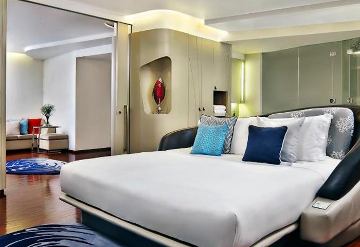 Baraquda Pattaya Mgallery luxury hotel room. Modern interior, large bed with pillows, and stylish decor. LGBT-friendly hotel in Pattaya, Thailand.