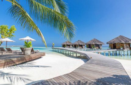 LUX* South Ari Atoll, Maldives over-the-water beach resort. Tropical gay travel destination with bungalows and wooden walkways.