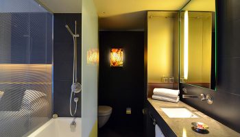 Hotel Soho Barcelona bathroom. Modern design, bath with shower, sink, mirror, and toilet. Gay-friendly hotel with cheap price.