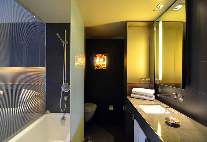 Hotel Soho Barcelona bathroom. Modern design, bath with shower, sink, mirror, and toilet. Gay-friendly hotel with cheap price.