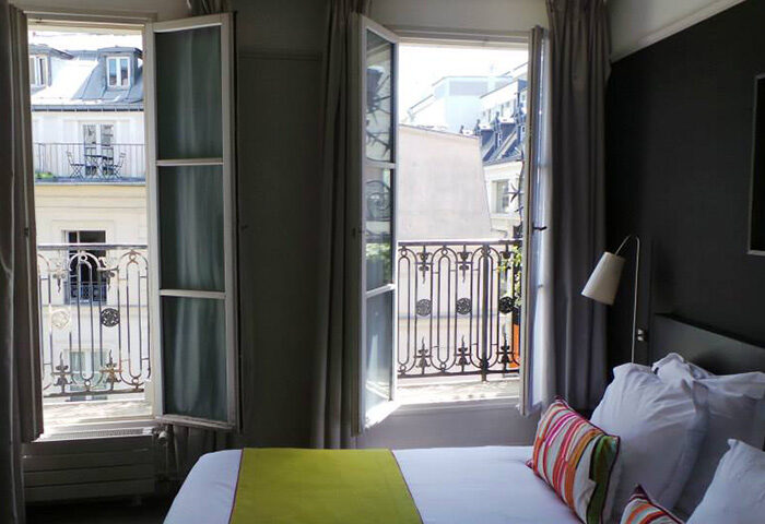 Duo Hotel, a cheap gay hotel in Paris' Marais district: Room view with open windows and balcony. A great gay travel idea for your trip.