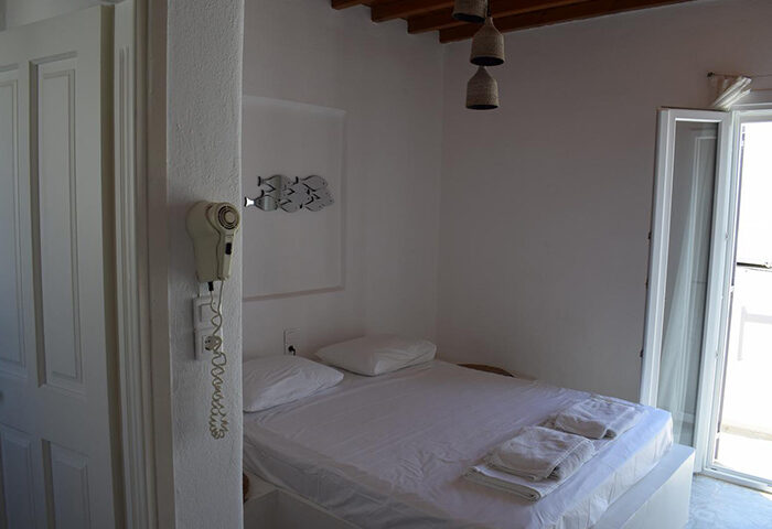 M for Mykonos: Cheap price gay hotel room in Mykonos Town (Chora) near Panagia Church. Simple, clean, white decor. Balcony access.