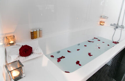 Bathtub with rose petals and candles at L'Empire Paris Hotel, a cheap-price gay hotel in Paris. Luxury gay travel experience.
