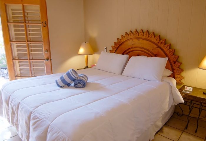 El Mirasol Villas, Palm Springs. Room interior at gay men-only resort. Bed with white linens and striped towels. Vacation travel.