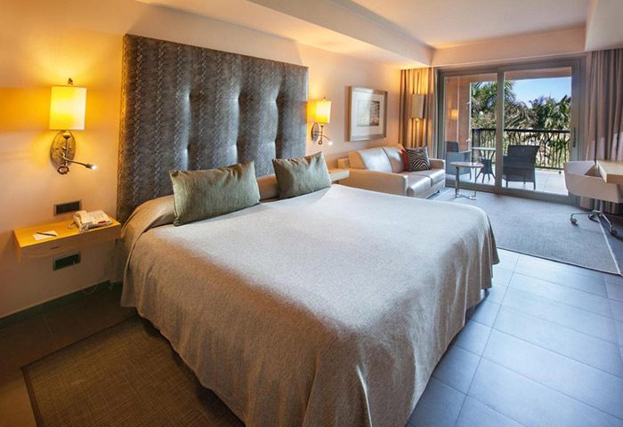 Lopesan Baobab Resort room. Gay-friendly luxury hotel in Gran Canaria, near Meloneras gay beach. Balcony view, comfy bed, and stylish decor.