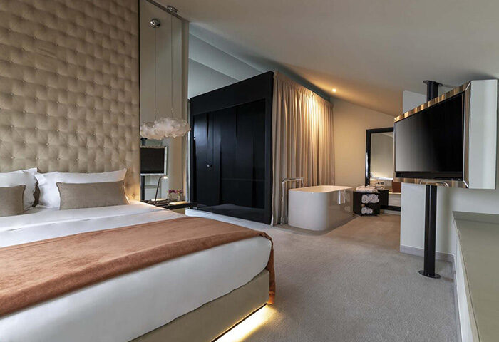9Hotel Mercy Lisbon room. Luxury gay hotel near gay nightlife. Bedroom with bed, bathtub, and TV. Cheap price for gay travel.