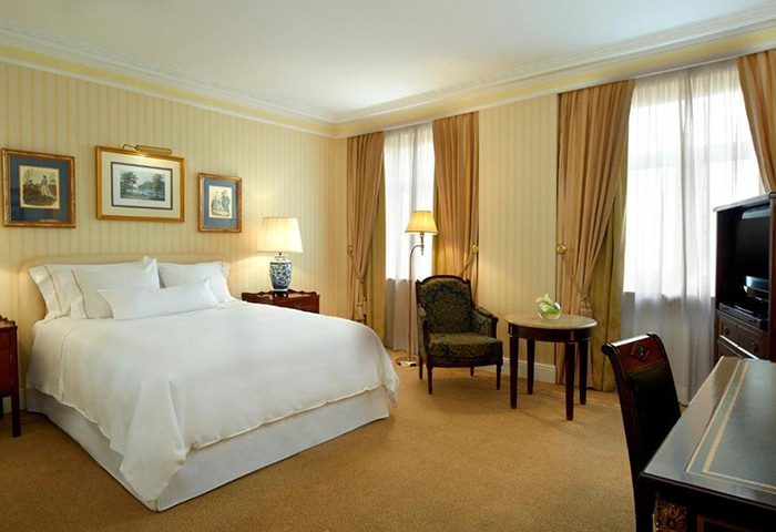 The Westin Palace, Madrid: Luxurious hotel room with a large bed, desk, and chair. Near gay bars and gay saunas, a great choice for gay travel.