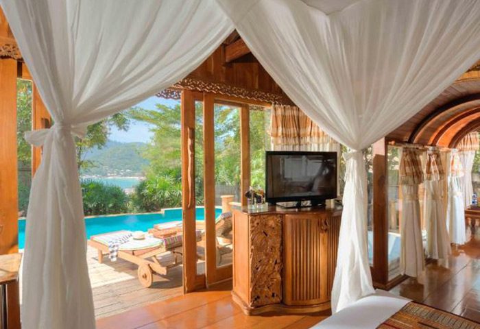 Santhiya Koh Phangan Resort & Spa villa. Luxury private pool view from bedroom. Gay hotel in Koh Phangan, Thailand. Deck chairs visible.