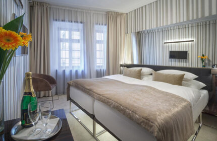 Hotel Clementin Old Town room. Upscale gay hotel in Prague city center. Champagne, flowers, and double bed. Striped wallpaper.