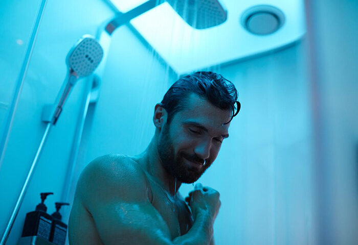 citizenM Copenhagen Radhuspladsen: Gay man showering in blue light. Upscale hotel in Vesterbro gayborhood. Cheap and stylish hotel.
