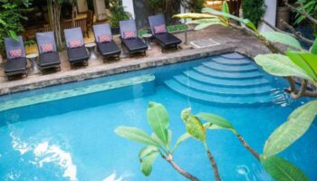 Rambutan Resort Siem Reap's outdoor pool with lounge chairs. A cheap and charming gay hotel in Siem Reap for gay travelers.