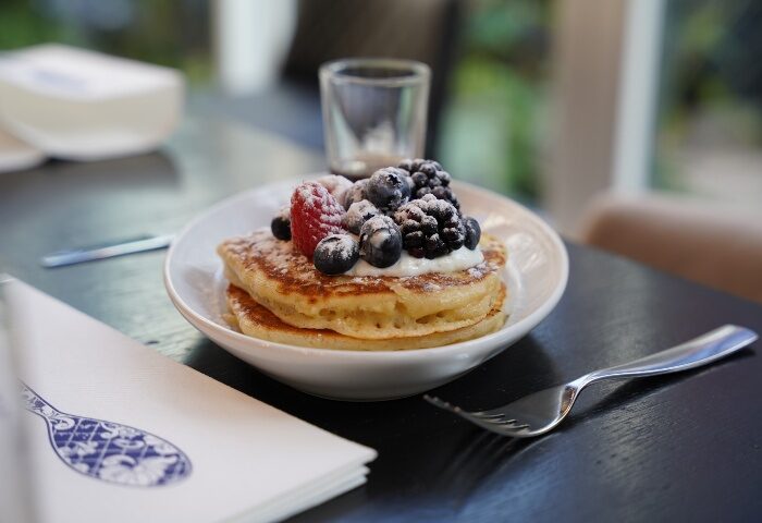 Andaz Amsterdam Prinsengracht Hotel cafe: Pancakes with berries and powdered sugar. Cheap and trendy gay hotel breakfast in Amsterdam.