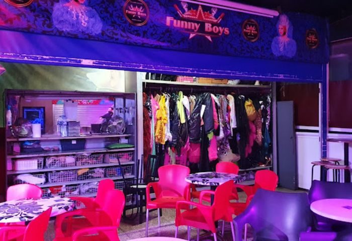 Chez Funny Boys gay bar in Gran Canaria. Interior view with costumes, tables, and chairs. A popular gay nightlife spot for men travelers.