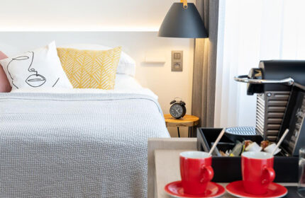 Mosaic House Design Hotel, Prague: Chic room detail. Gay-friendly hotel with modern design, bed, coffee machine, and red cups. Old Town stay.