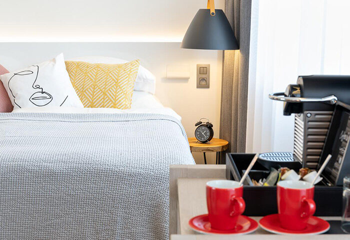 Mosaic House Design Hotel, Prague: Chic room detail. Gay-friendly hotel with modern design, bed, coffee machine, and red cups. Old Town stay.