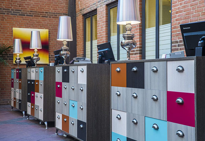 Comfort Hotel Vesterbro's chic design: reception desks with colorful drawers, modern lamps, and brick walls. Gay-friendly hotel in Copenhagen.