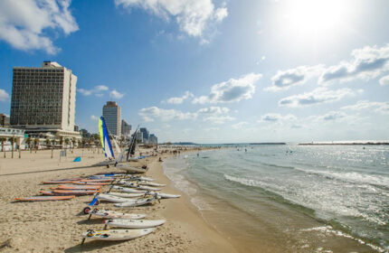 Hilton Beach, Tel Aviv. Brown Seaside Hotel view. Surfboards on the gay-friendly beach. Stylish seaside scene at Brown Hotels.
