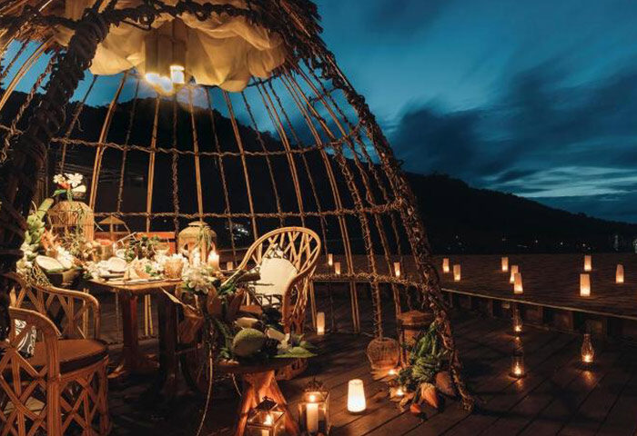 Romantic dinner at Keemala, Phuket. Chic and unique gay-popular hotel with a private dining area. Candles light the wooden deck.