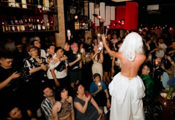 Drag queen performing at Chin Chin Bar in Ho Chi Minh City, Vietnam. Gay bar with a crowd of people holding up phones. Gay travel advice.