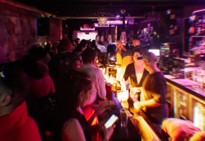 Ching-a-Lings Sydney bar scene. Gay travel advice: crowded bar with bartenders serving drinks, people socializing, and vibrant nightlife.