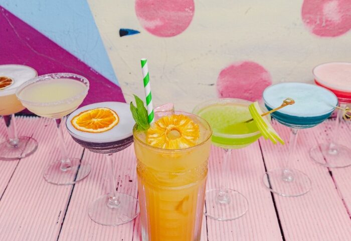 Colorful cocktails at Ching-a-Lings, Sydney. Variety of drinks, including orange, blue, green, and white cocktails. Gay travel advice.