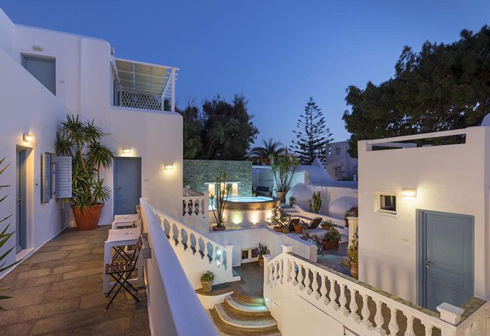 Carbonaki Hotel in Mykonos Chora. Central location near gay bars and gay cruise spots. Whitewashed buildings with a jacuzzi at dusk.