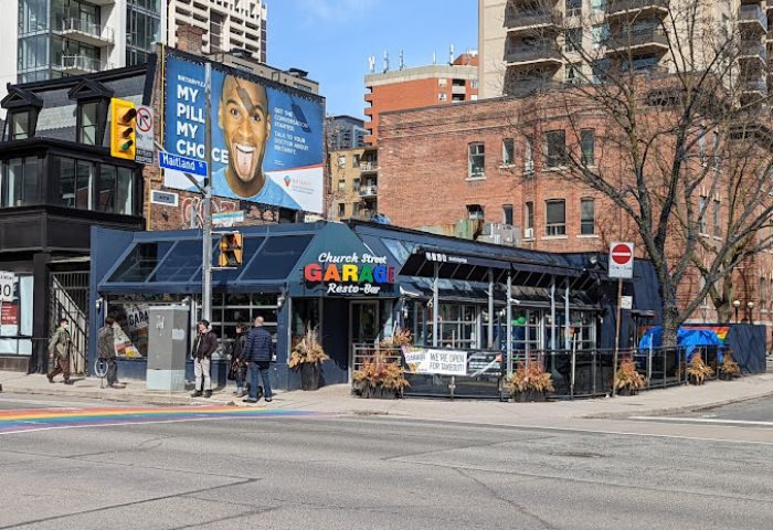 Church Street Garage Resto-Bar in Toronto, a popular gay-friendly spot. Rainbow crosswalk in front. Great for gay travel advice!