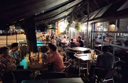 Church Street Garage Resto-Bar in Toronto: Outdoor patio view at night, people dining. A popular gay bar and restaurant in the Church-Wellesley Village.