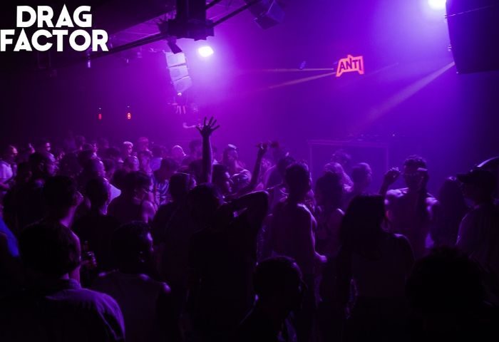 Packed dance floor at Churros con Chocolate, a gay club in Barcelona. Purple lighting, crowd of people dancing, nightlife scene.