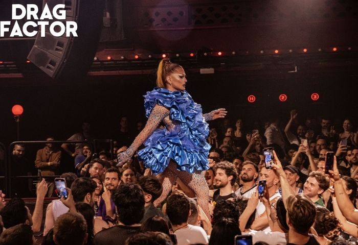 Drag queen in blue dress crowd surfing at Churros con Chocolate, a popular gay club in Barcelona. Gay nightlife travel advice.