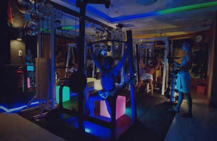 Gym at Club Bath Sauna Manila, a top gay sauna and cruising place. Men work out in a neon-lit space with disco balls. Gay travel advice.