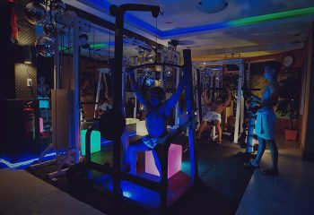 Gym at Club Bath Sauna Manila, a top gay sauna and cruising place. Men work out in a neon-lit space with disco balls. Gay travel advice.