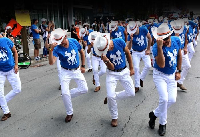 Montreal Gay Dance Party: Bolo Club dancers in white pants, cowboy hats, & blue shirts perform. Gay travel advice.
