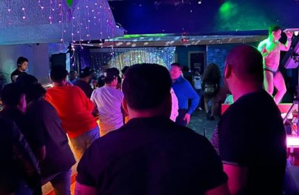 Inside Club OMG Gay Bar in San Francisco, crowd watches a dancer on stage. Nightlife scene, gay travel destination.