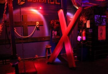 Open Mind Gay Cruise Club in Barcelona: Dark room with a St. Andrew's cross, chains, and other BDSM equipment. Nightlife for gay men.