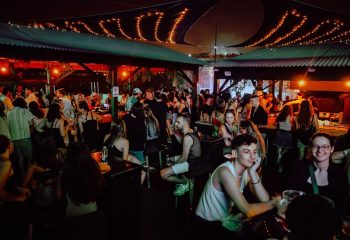Montreal's Unity gay club party scene. Crowd of people socializing at a lively bar, enjoying the night. Gay travel destination.