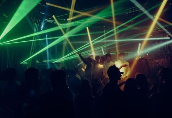 Montreal gay party at Club Unity. Crowd dancing under green and yellow laser lights. Gay nightlife travel advice.
