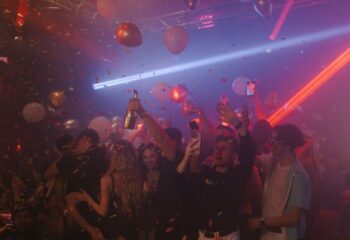 Montreal gay party at Club Unity. People celebrate with champagne, balloons, and confetti. Nightlife scene with laser lights. Gay travel advice.