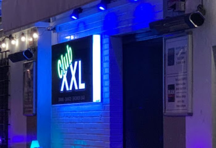 Club XXL Gay Club in Sitges. Night view of the entrance with the illuminated sign. Gay travel advice for Sitges, Spain.