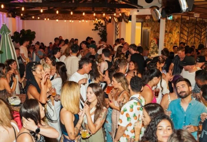 Crowded bar scene at Colombian Hotel Sydney. Gay travel hotspot with diverse crowd, drinks, and vibrant atmosphere. Popular gay bar in Sydney.