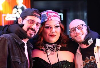 Two men with a drag queen at Coming Out Bar, Rome. Gay travel advice, Rome's gay scene, LGBTQ+ nightlife. Smiling faces, fun times.