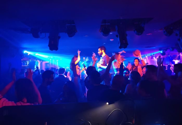 Sky Complex, a gay bar in Montreal, Canada. Crowd of people dancing under blue lights. Gay travel destination, nightlife, bar scene.