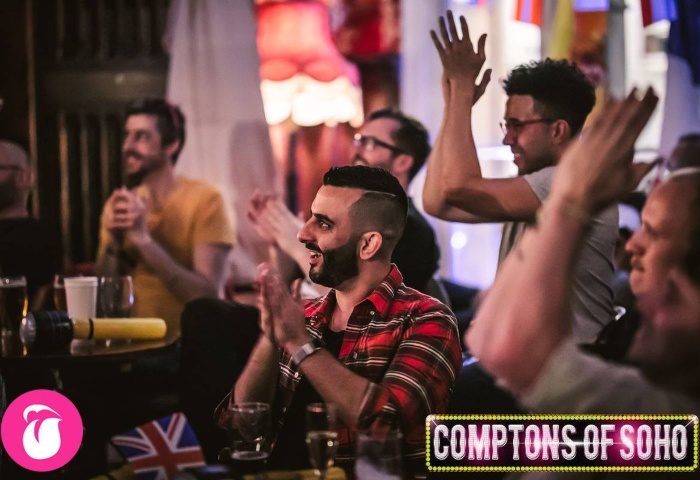 Crowd at Comptons of Soho, London, a popular gay bar. Men are clapping and cheering. Daddy gay bar scene in Soho.
