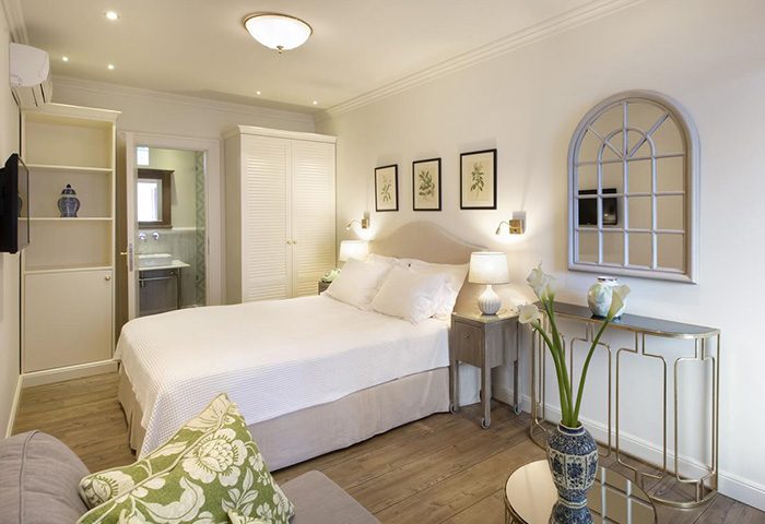 Despotiko Hotel Mykonos room with minimalist design. Honeymoon suite, Chora. Gay travel luxury hotel. White decor, double bed, ensuite bathroom.