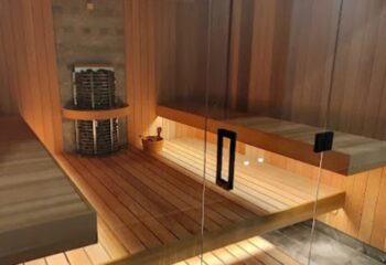 Cool spa sauna in Ho Chi Minh City. Wooden benches, heater, and glass door. Gay travel advice for relaxation and wellness. Vietnam spa day.