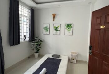 Cool Spa in Ho Chi Minh: Massage room with bed, plant art, and window. Gay travel spa day in Vietnam. Relaxing wellness experience.