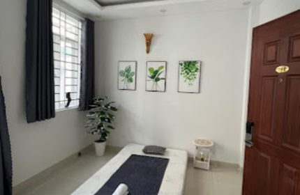 Cool Spa in Ho Chi Minh: Massage room with bed, plant art, and window. Gay travel spa day in Vietnam. Relaxing wellness experience.